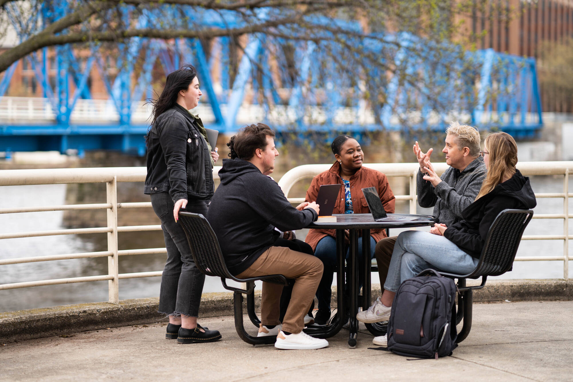 Graduate students chatting with their professor.